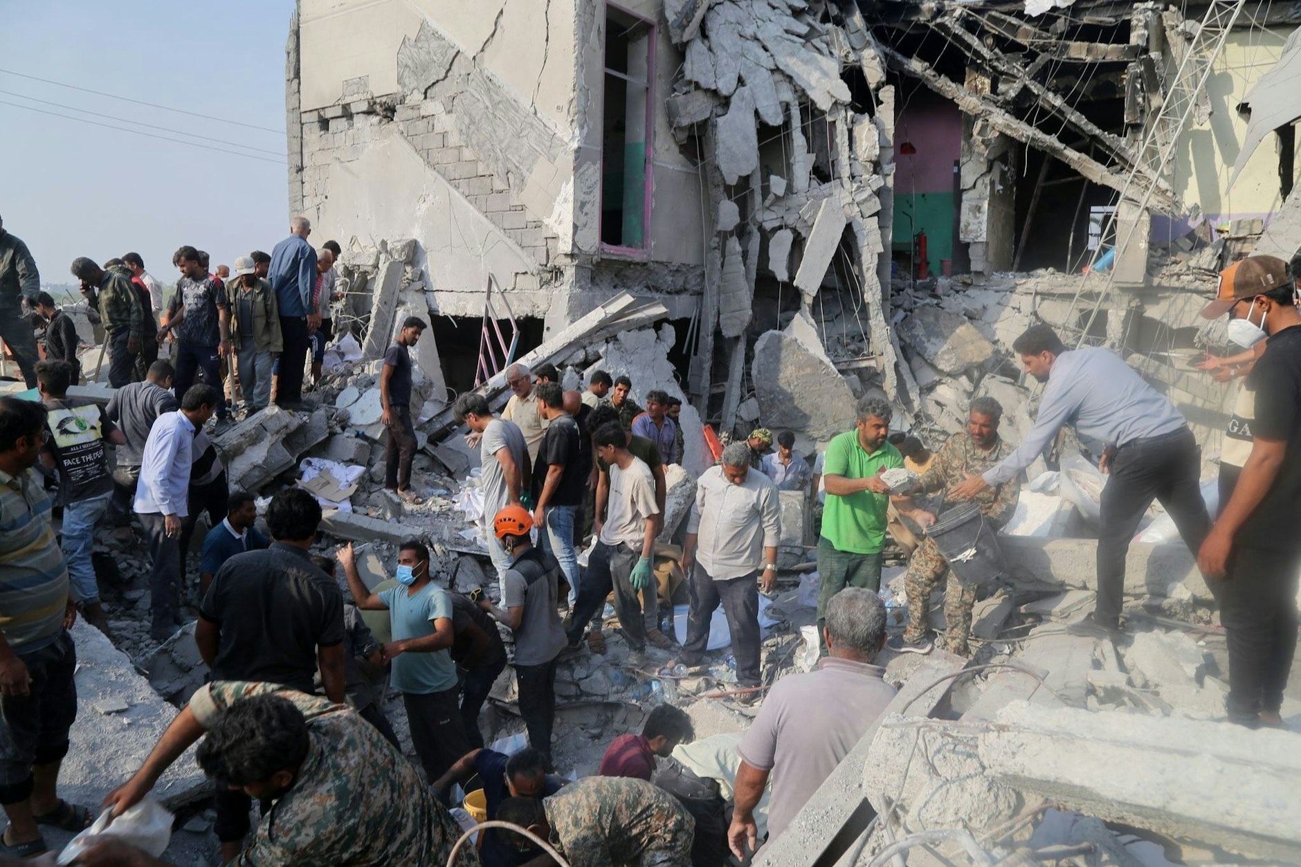 Rettungskräfte und Anwohner durchsuchen am 28. Februar 2026 die Trümmer der Grundschule für Mädchen in Minab.