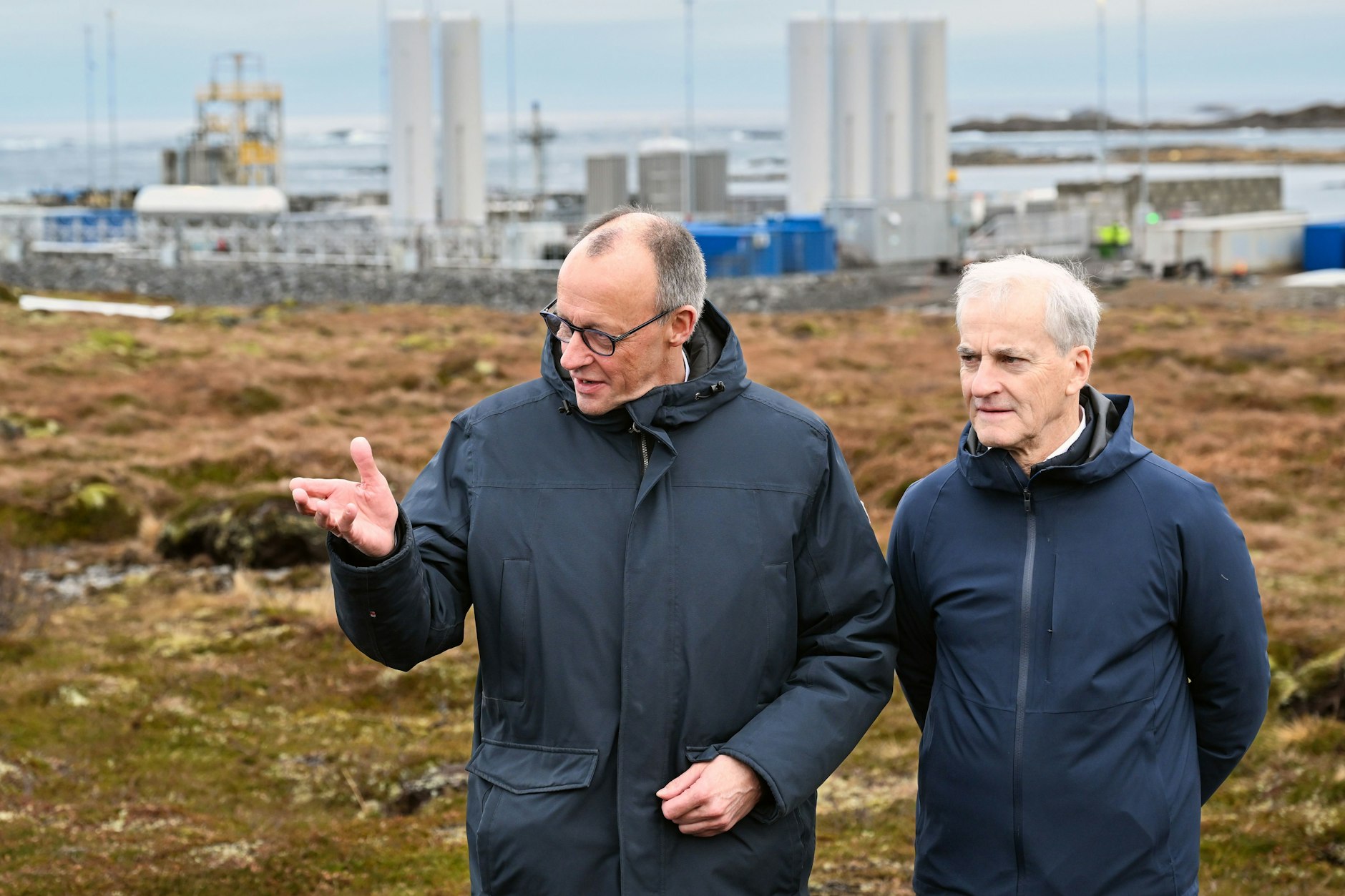 Friedrich Merz steht mit dem norwegischen Ministerpräsidenten Jonas Gahr Støre vor der Raketenstartrampe in Norwegen.