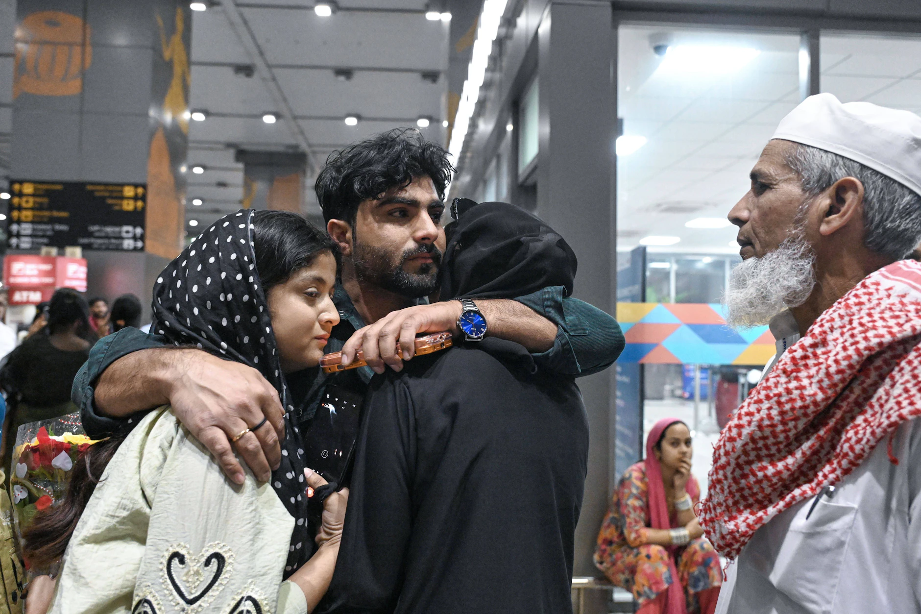 Indische Passagiere werden nach einem Flug über Dubai am Flughafen in Neu-Delhi von ihren Familien empfangen.