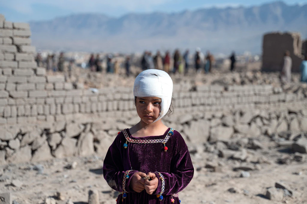 Ein verletztes afghanisches Mädchen steht neben beschädigten Häusern nach einem pakistanischen Luftangriff.