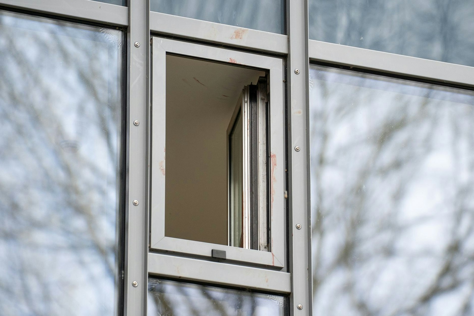 Mehrere Blutspuren sind am Rahmen eines Hotelfensters zu sehen.