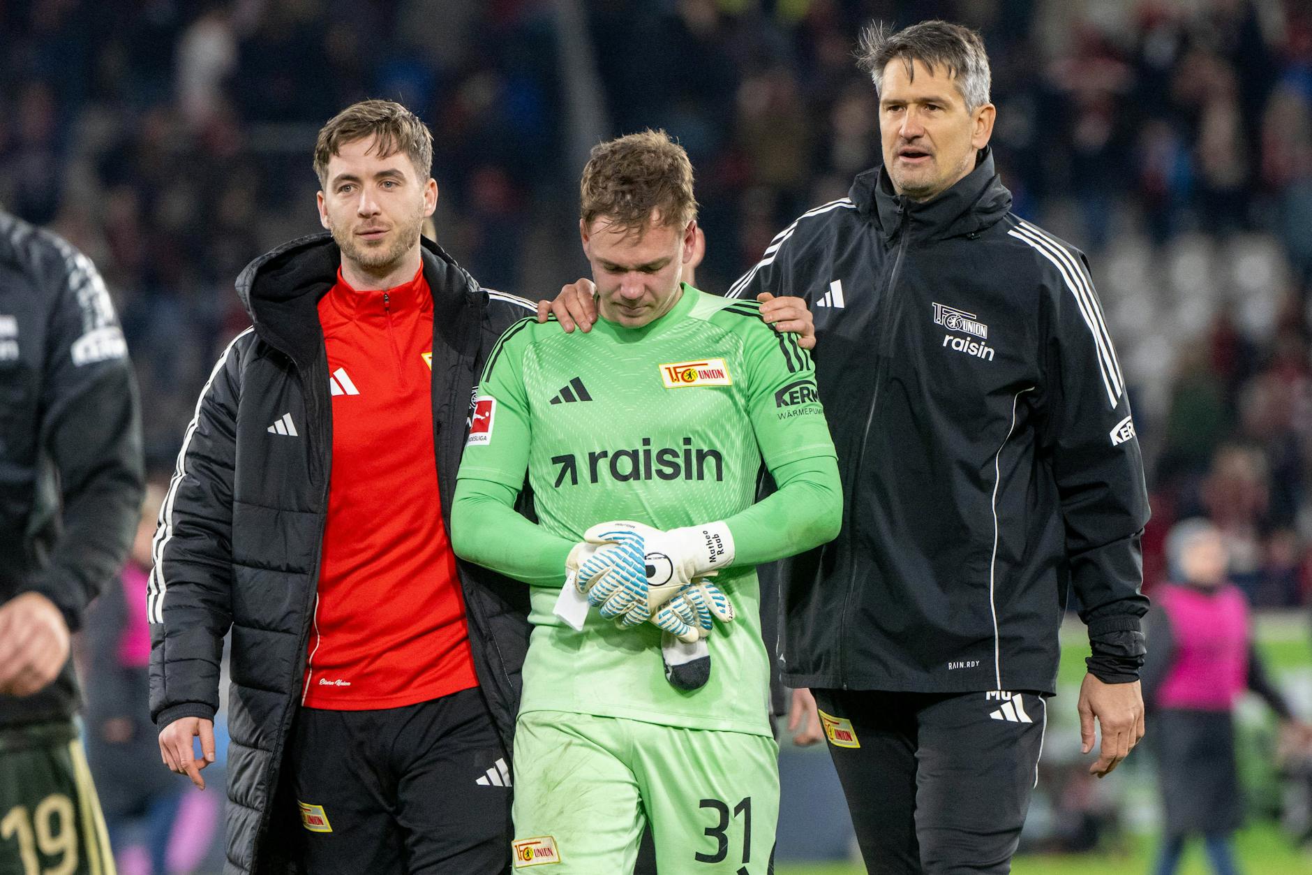 Torhüter Carl Klaus und Torwarttrainer Michael Gspurning (r.) trösten Matheo Raab nach dem Sieg des 1. FC Union Berlin beim SC Freiburg.