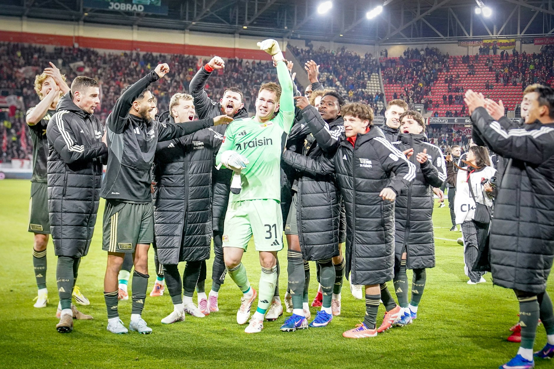 In der Nachspielzeit und nach der Partie im Blickpunkt: Union-Torhüter Matheo Raab wird von seinen Mitspielern gefeiert.