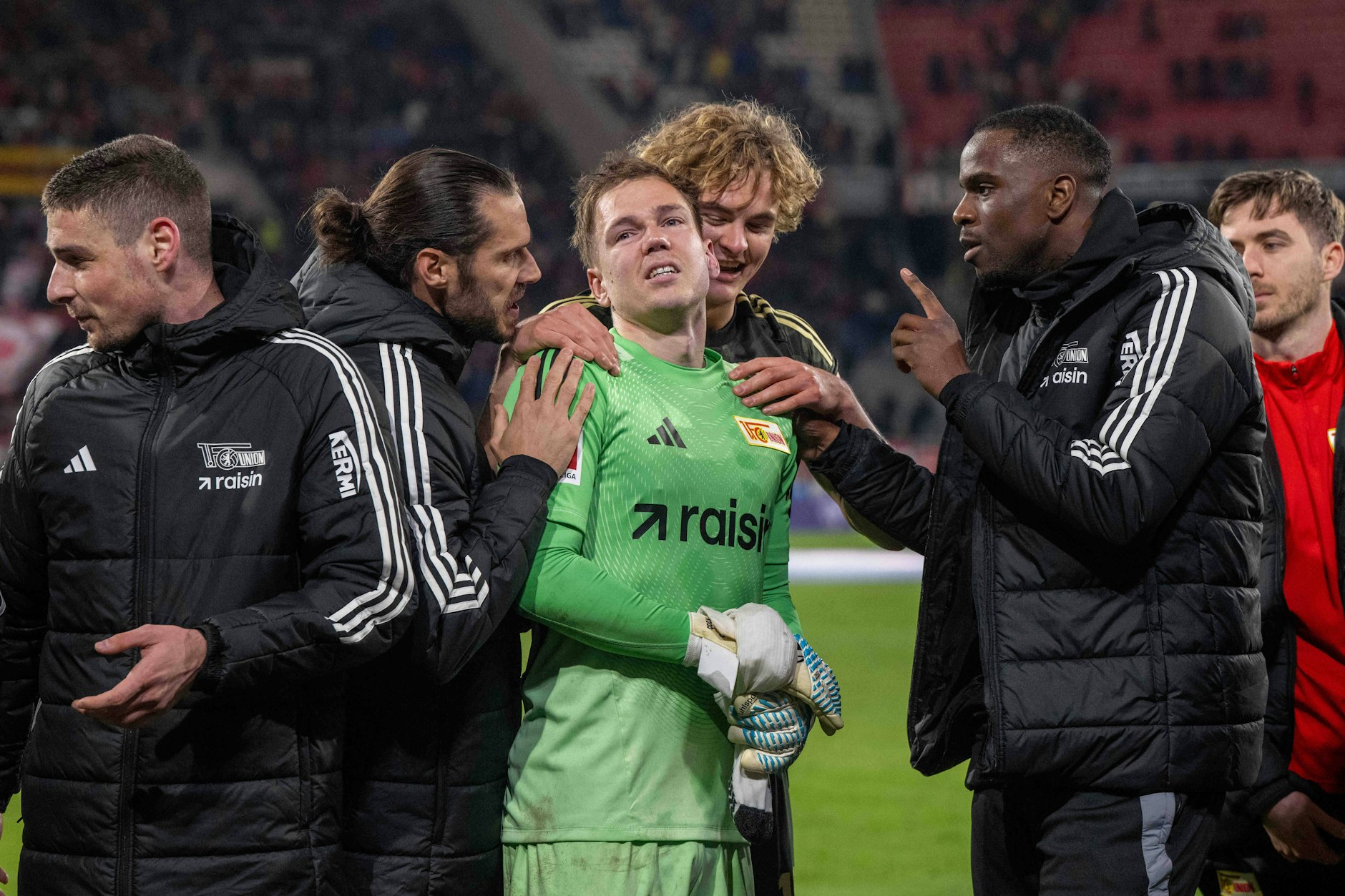 Die Spieler des 1. FC Union Berlin wissen, bei wem sie sich bedanken müssen. Torhüter Matheo Raab pariert in der Nachspielzeit einen Distanzschuss mit wohl gebrochener Hand. Erst in der Saison 2024/25 war der Keeper mit einer Handverletzung mehr als vier Monate ausgefallen.