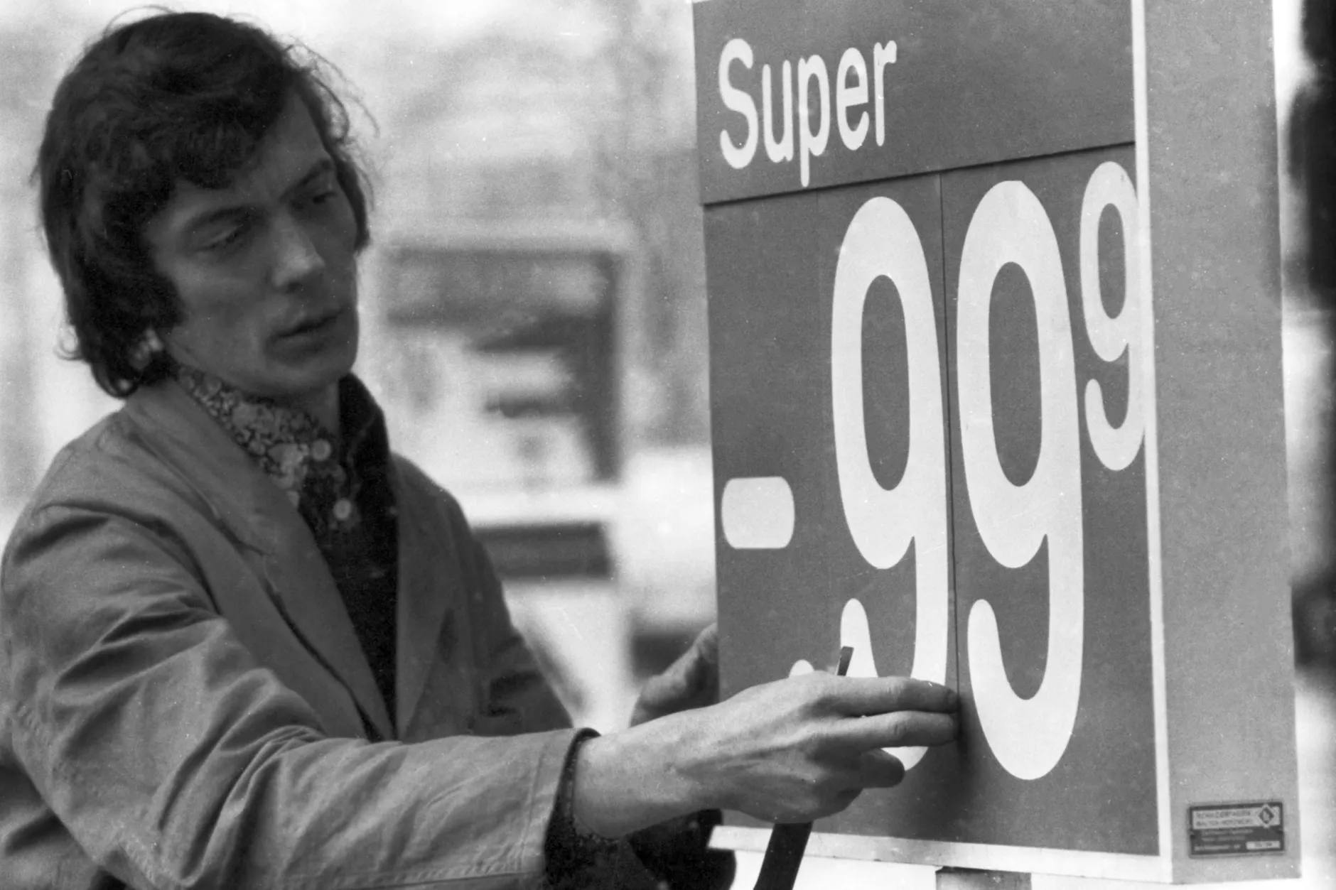 Ein Tankstellenmitarbeiter wechselt Anfang Februar 1976 die Preistafel für Superbenzin.