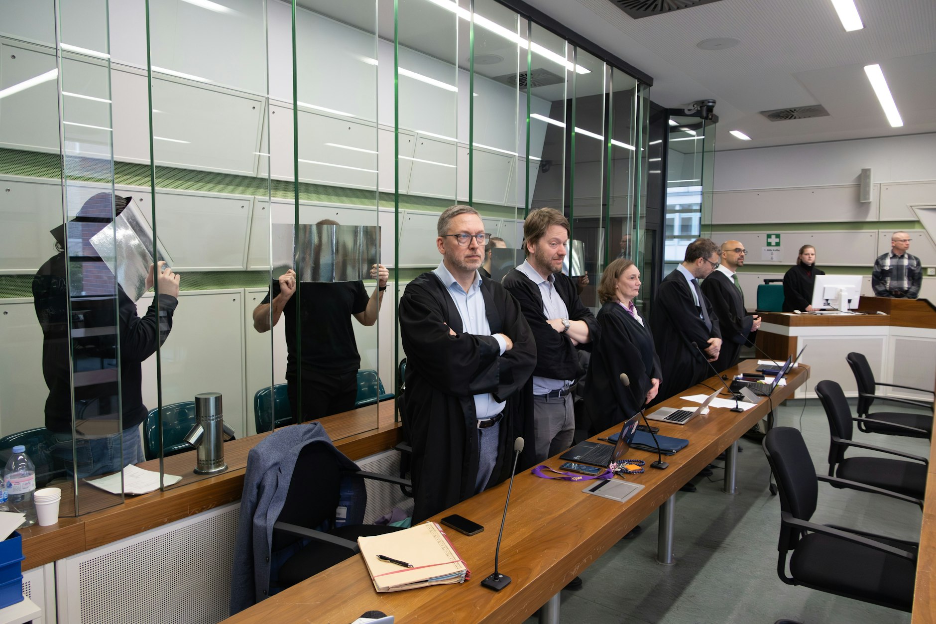 Prozessauftakt am Landgericht Berlin: Die Angeklagten, darunter Angehörige der Großfamilie Remmo, verbergen ihre Gesichter hinter Sichtschutzmappen.