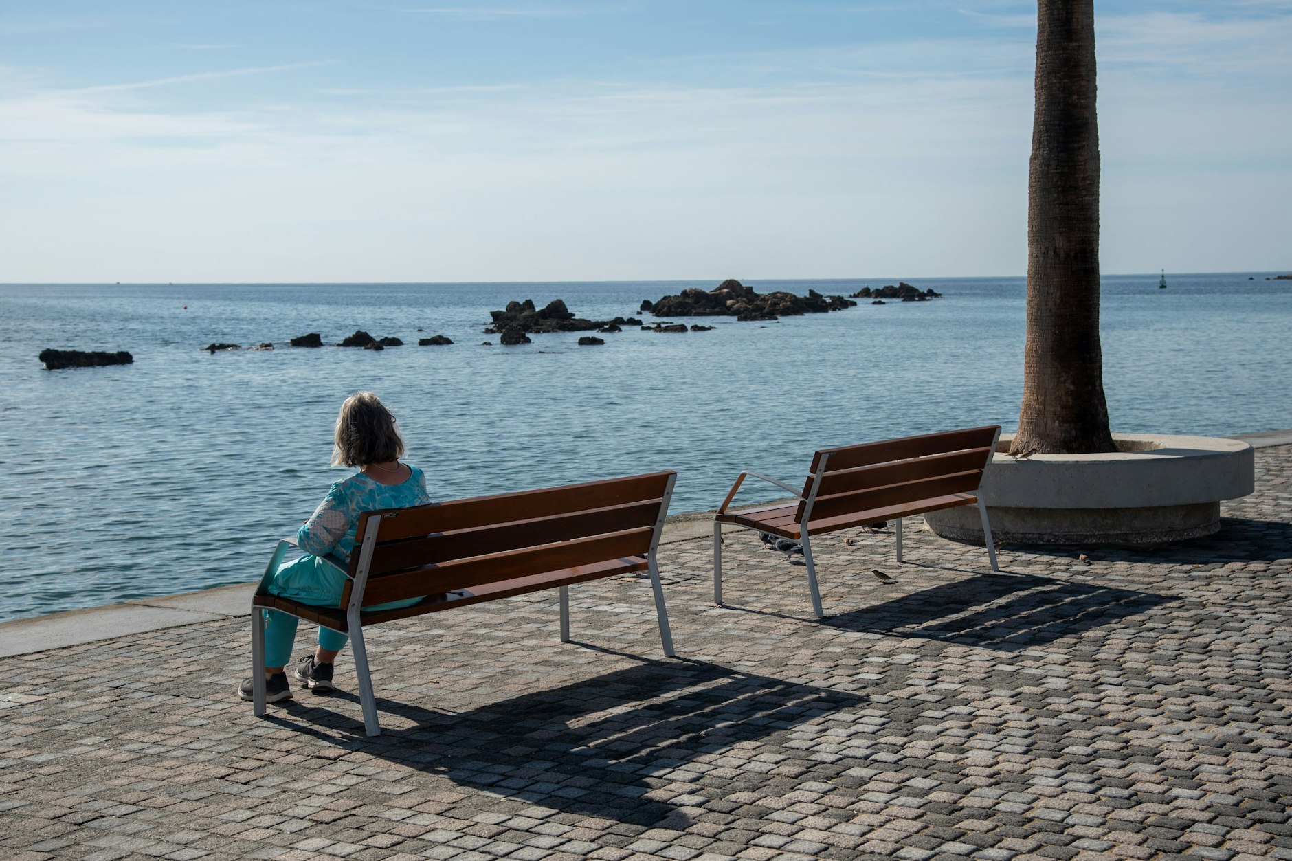 Eine Frau genießt in Paphos den Blick auf das Meer.