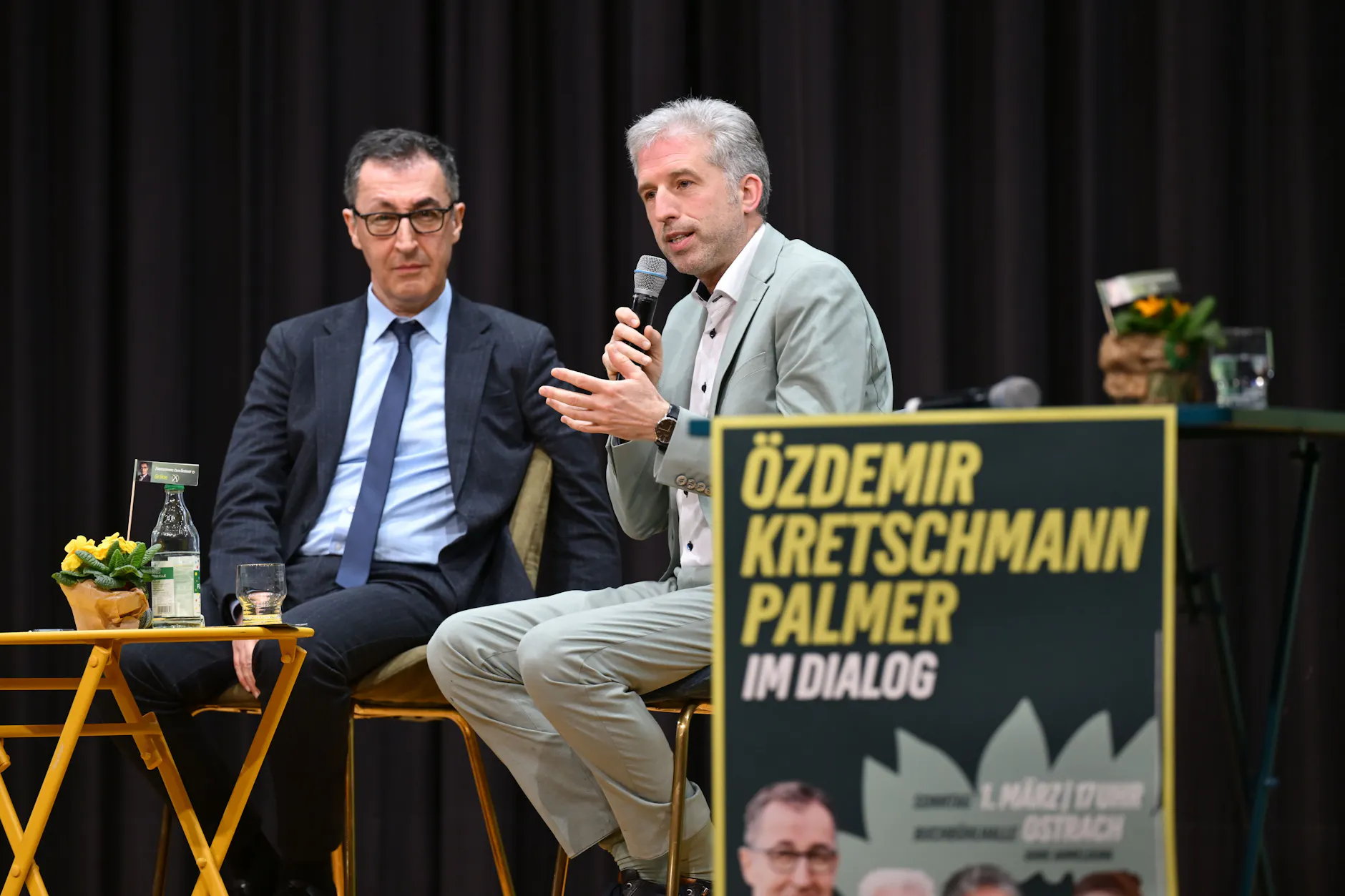 Cem Özdemir (Grünen) und Boris Palmer (parteilos) sprechen auf einer Bühne bei einer Wahlkampfveranstaltung der Grünen.