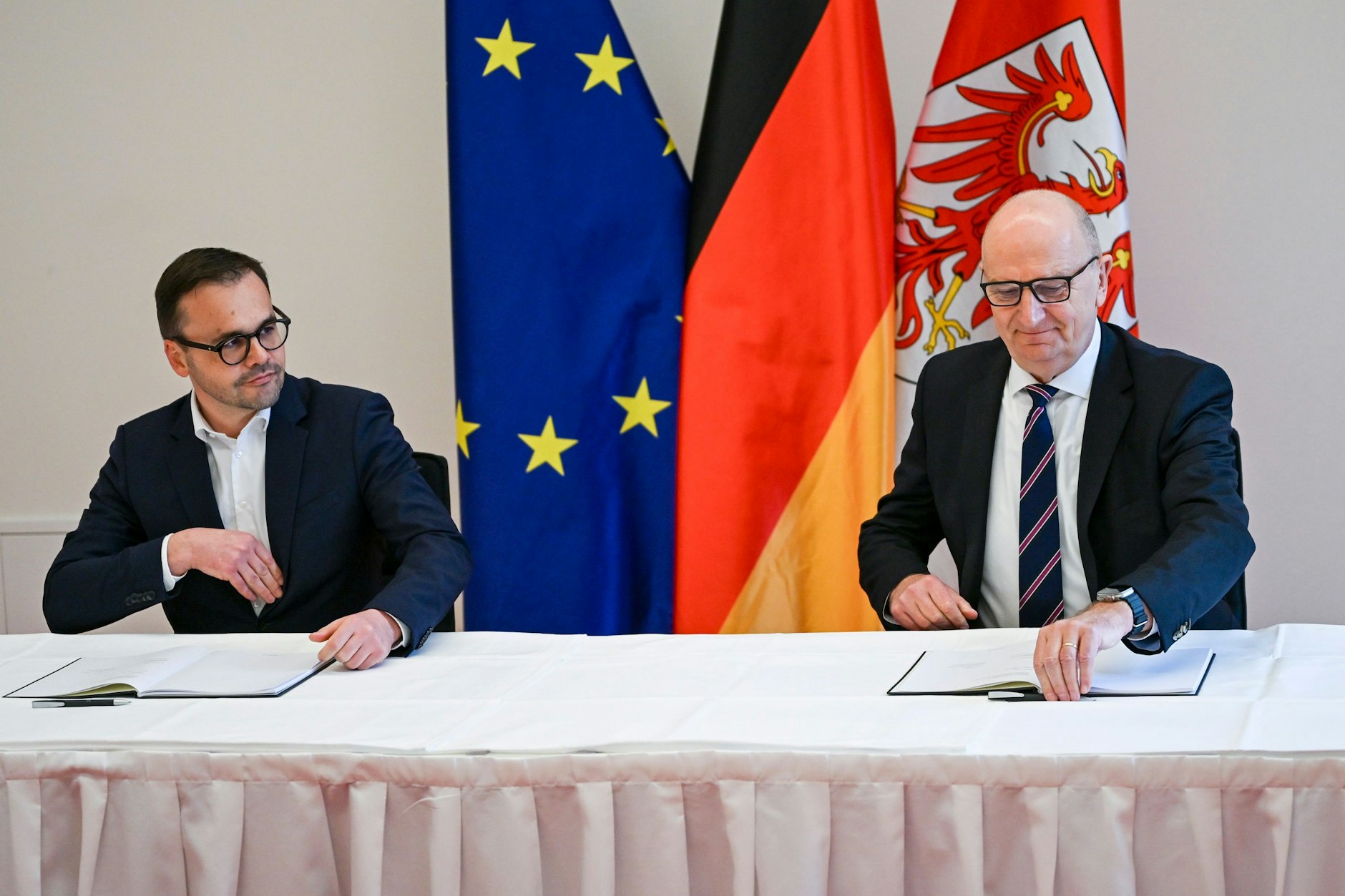 Jan Redmann (l, CDU), Vorsitzender der Brandenburger CDU, und Dietmar Woidke (SPD), Ministerpräsident von Brandenburg, unterzeichnen den Brandenburger Koalitionsvertrag.
