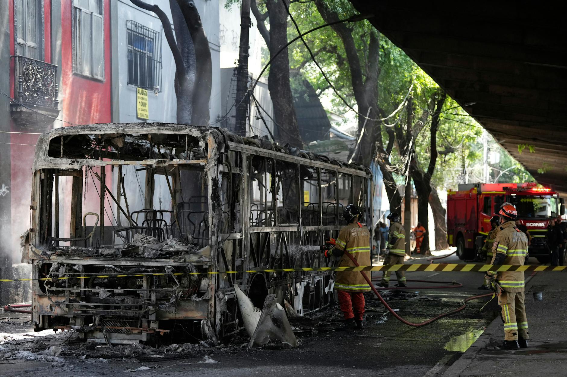 Feuerwehrleute löschten in Rios Stadtteil Morro dos Prazeres einen Bus, den Kriminelle nach dem Polizeieinsatz in Brand gesetzt hatten.