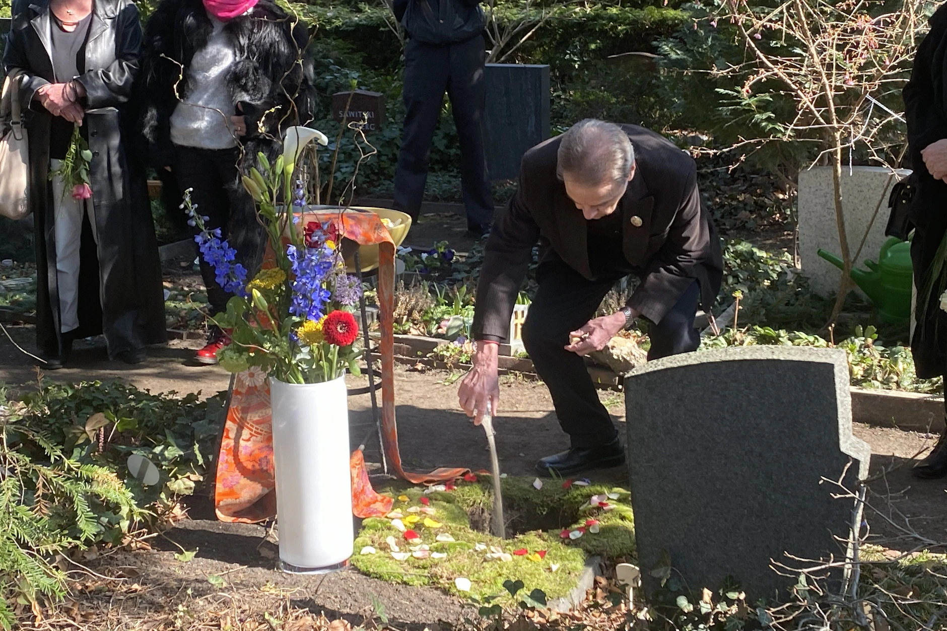 Es ist ein Zeichen seiner Liebe: Ralf Rasch schüttet Sand vom Nordseestrand in das Grab seiner verstorbenen Frau Angelika Mann.