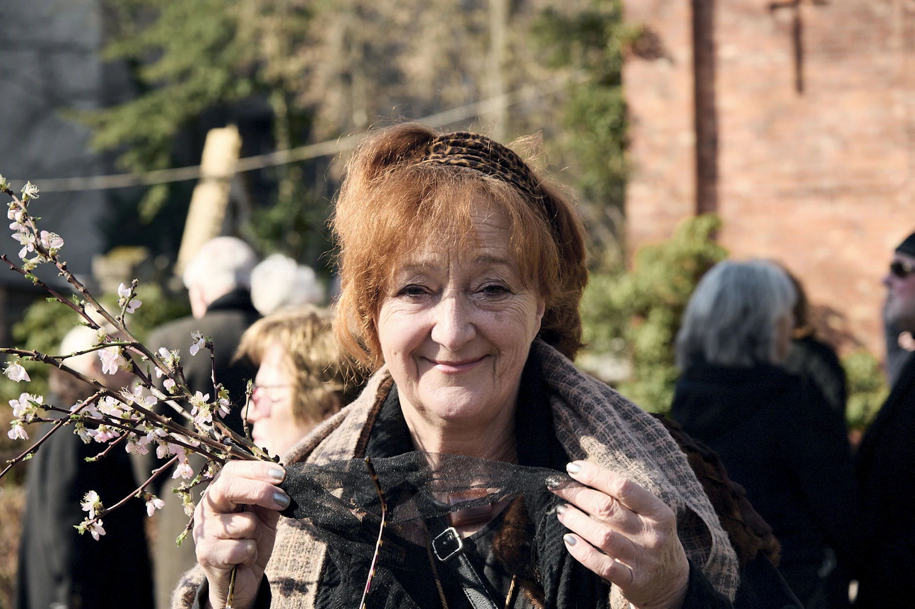 Entertainerin Dagmar Gelbke mit einem blühenden Pfirsichzweig aus ihrem Garten.