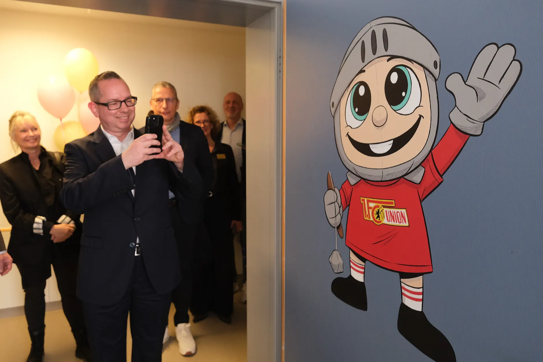 Bezirksbürgermeister Oliver Igel fotografiert die Tür zum Union-Familienzimmer.