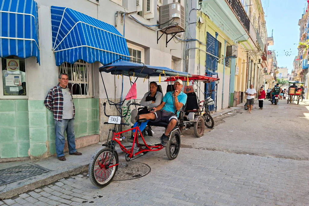 Wegen des Treibstoffmangels fahren Touristen auf Rikschas durch Havanna.