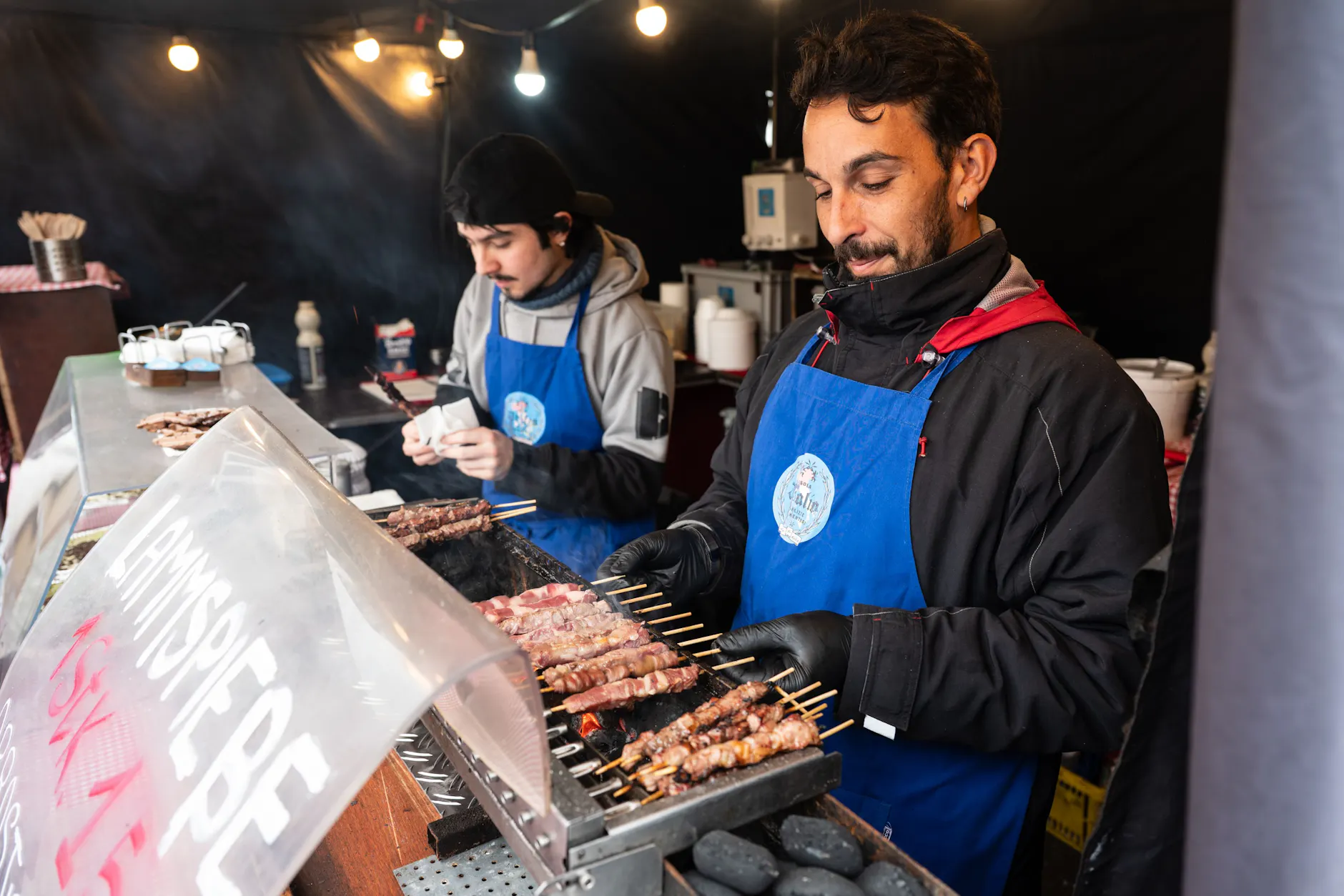 Michele Favallo (r.) bereitet beim Berlin Chocolate Festival Lammspieße mit belgischer Schokolade zu.