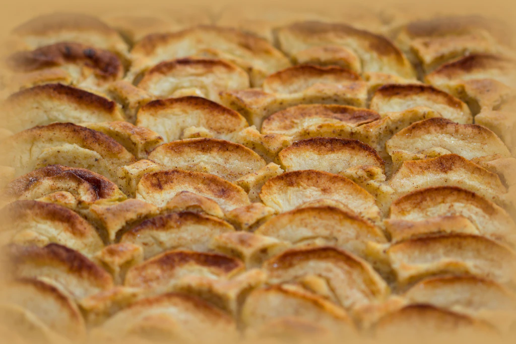Dachziegelartig werden die Apfelschlitze auf dem Teig ausgelegt und gebacken.