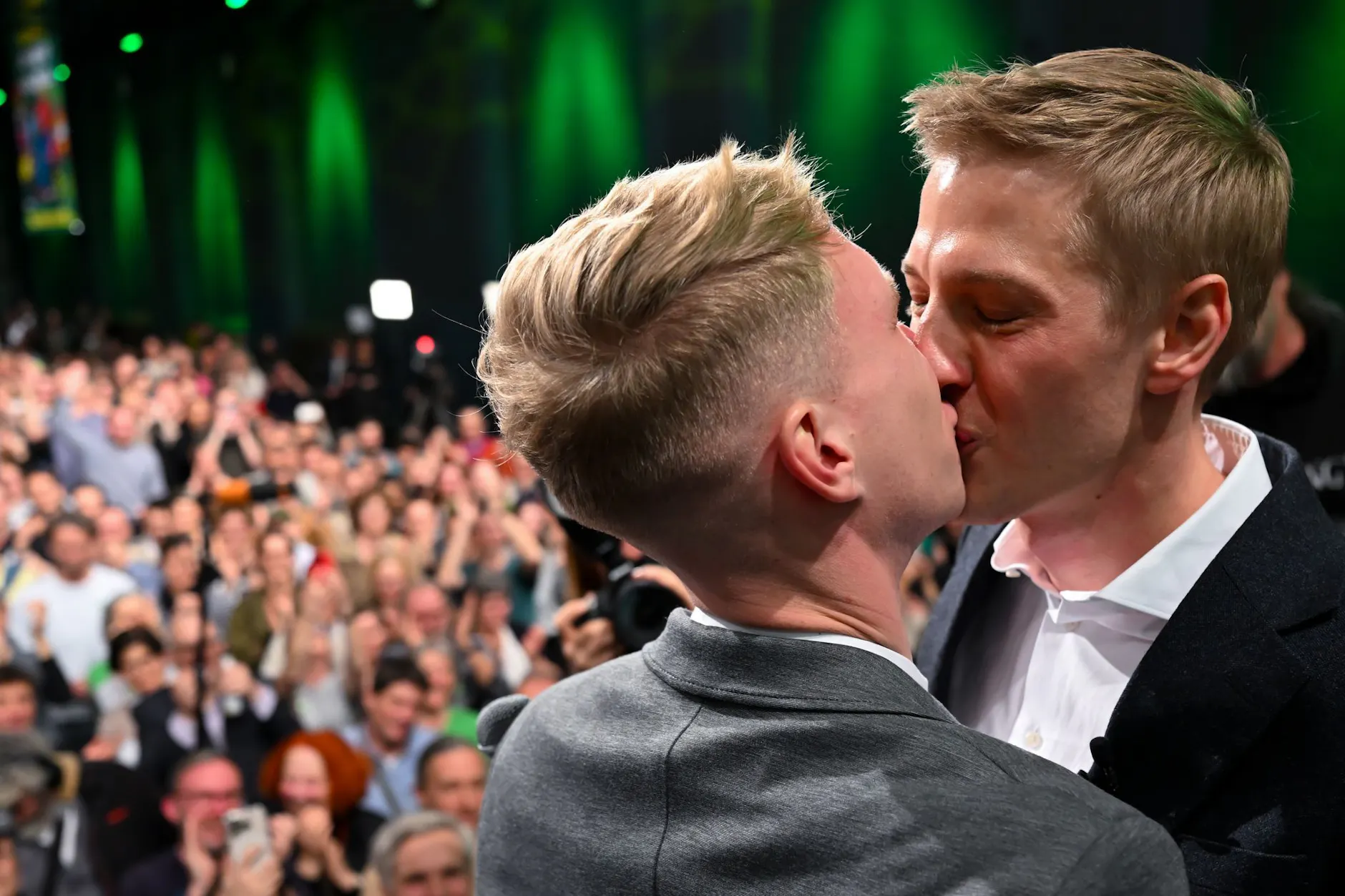 Dominik Krause (r.) und sein Freund Sebastian Müller stehen bei der Wahlparty der Grünen auf der Bühne und küssen sich.