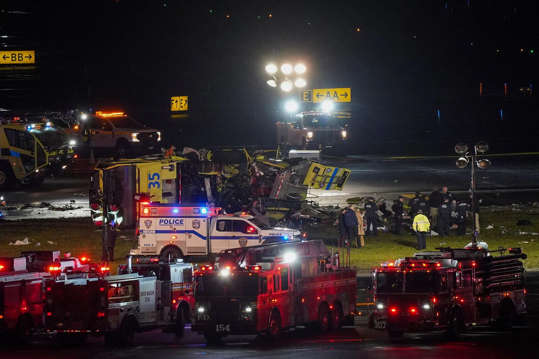 Ein Rettungs- und Feuerlöschfahrzeug der Hafenbehörde liegt auf der Seite neben Landebahn 4, nachdem es mit einem Air-Canada-Flugzeug kollidiert ist, das auf dem Flughafen LaGuardia gelandet war.