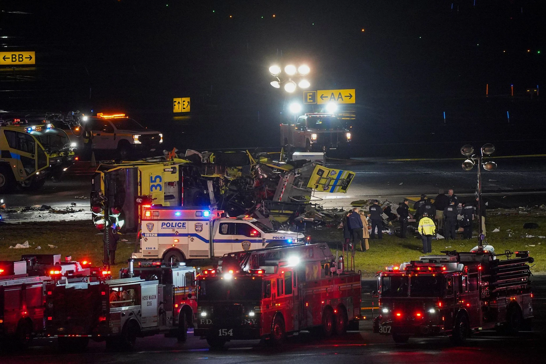 Ein Rettungs- und Feuerlöschfahrzeug der Hafenbehörde liegt auf der Seite neben Landebahn 4, nachdem es mit einem Air-Canada-Flugzeug kollidiert ist, das auf dem Flughafen LaGuardia gelandet war. 