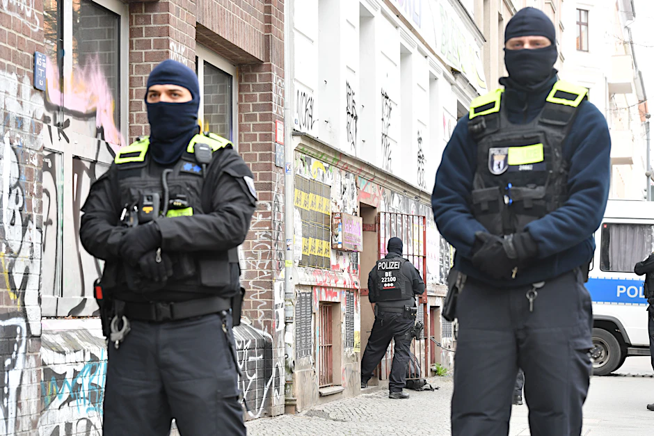 Vermummte Polizeibeamte versperren in der Reichenberger Straße den Zugang zur Bibliothek Kalabalik.