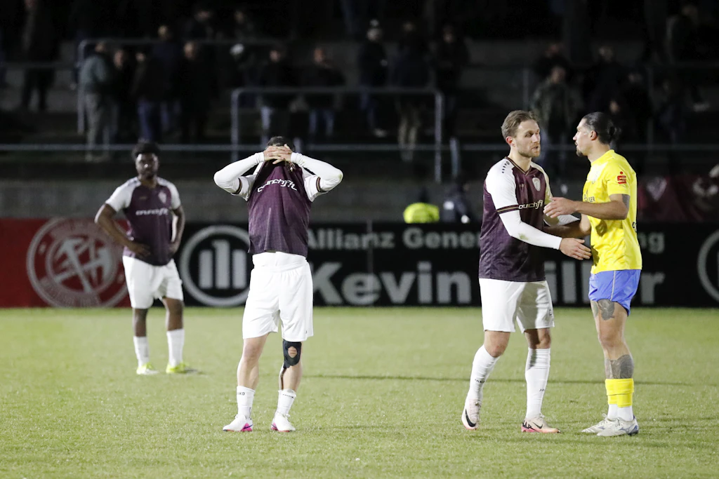 Jan Shcherbakovski mag nicht mehr hinsehen, zieht sich Trikot und Hände vor die Augen. Rechts daneben sprechen Leandro Putaro und Andreas Pollasch, ein Ex-Dynamo im Luckenwalde-Dress. Links: Lloyd Kuffour