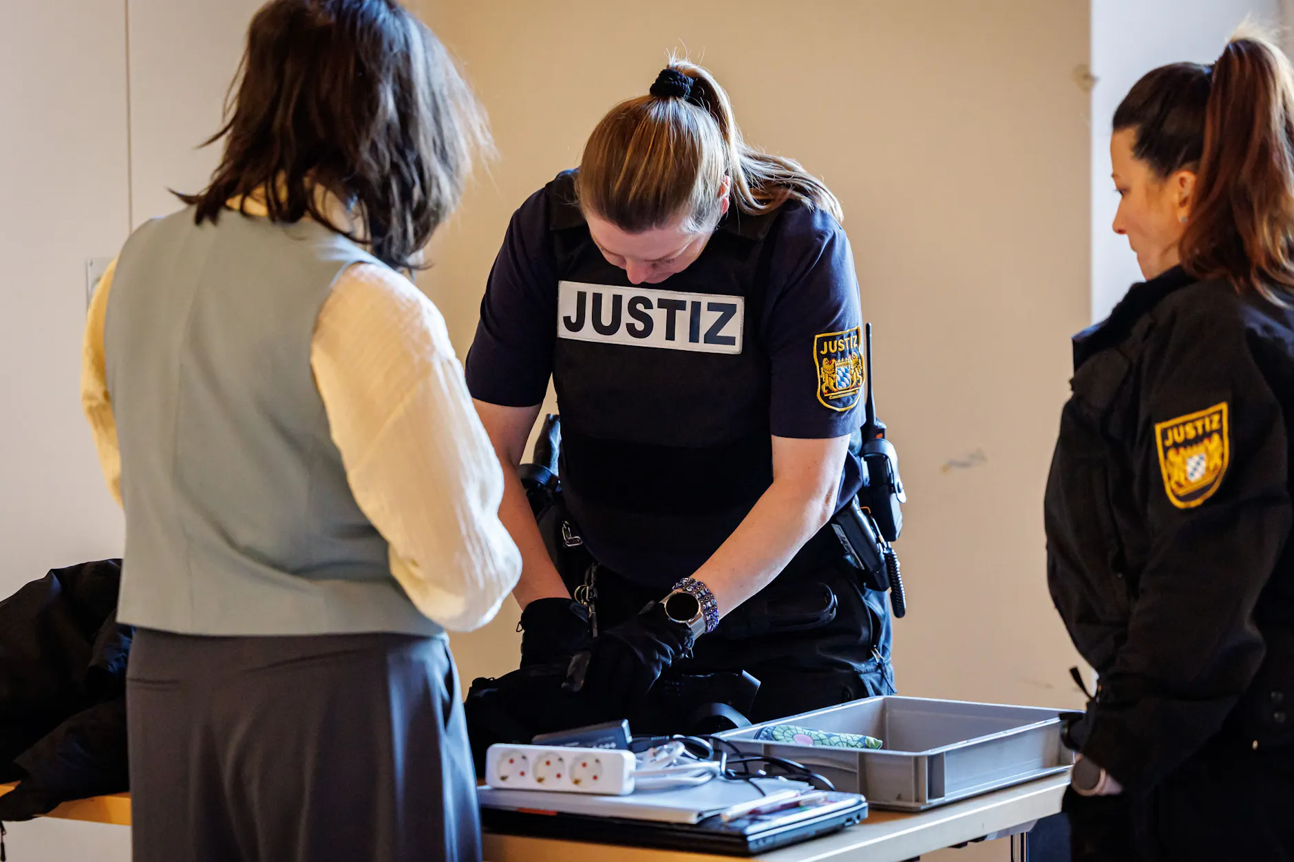 Eine angeklagte Klimaaktivistin (l) wird beim ihrem Eintreffen im Amtsgericht Nürnberg von einer Justizmitarbeiterin kontrolliert.