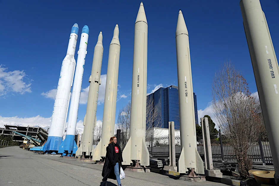 Eine Frau passiert im Norden Teherans eine Dauerausstellung mit im Iran produzierten Raketen und Satellitenträgern.