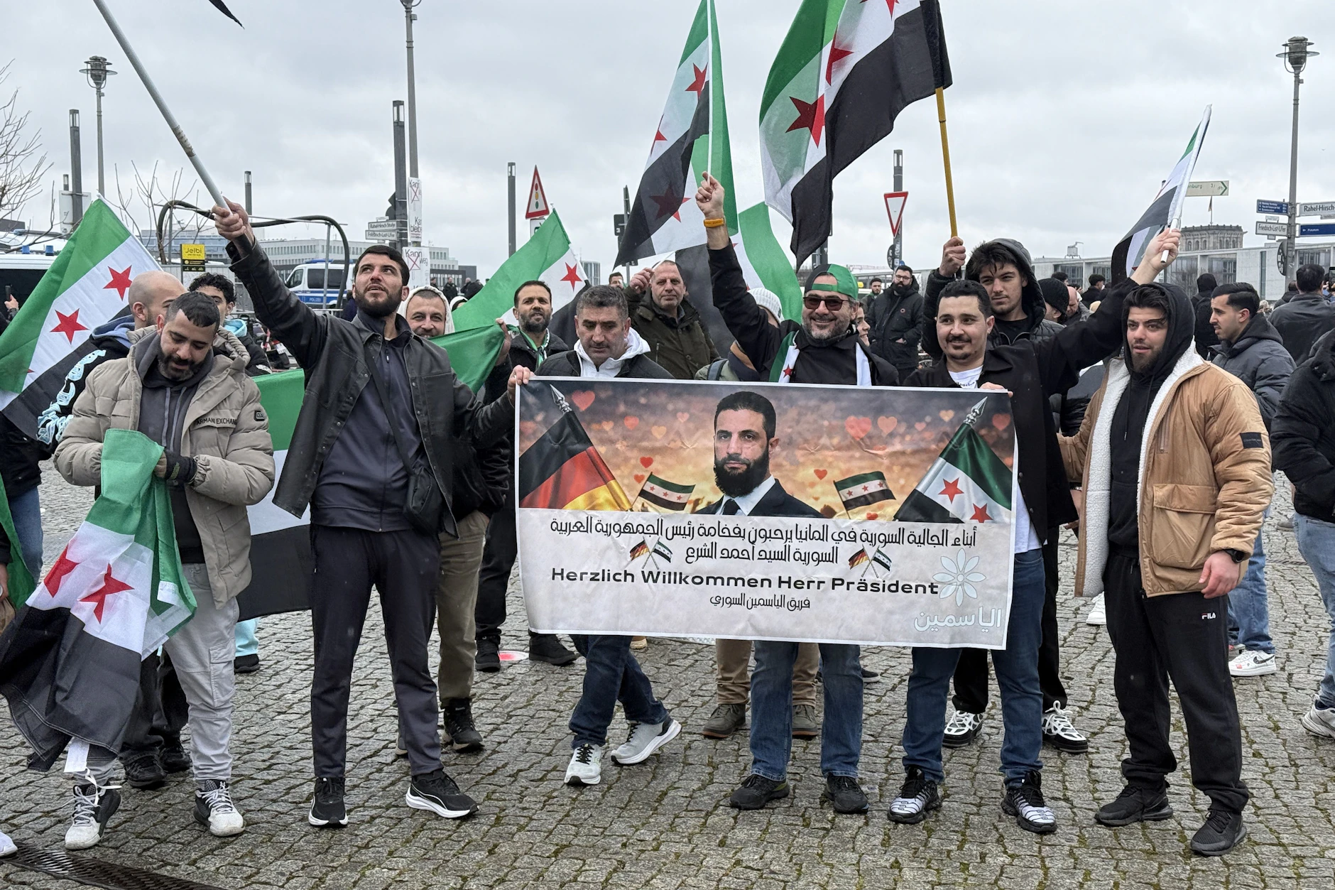 Vor dem Berliner Hauptbahnhof heißen Syrer ihren Übergangspräsidenten bei einer Demo willkommen.
