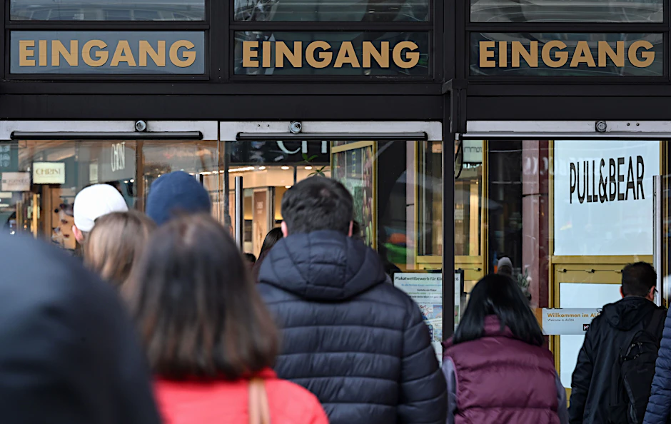 Mehrere Menschen laufen auf den Eingang des Einkaufszentrums Alexa in Berlin zu.