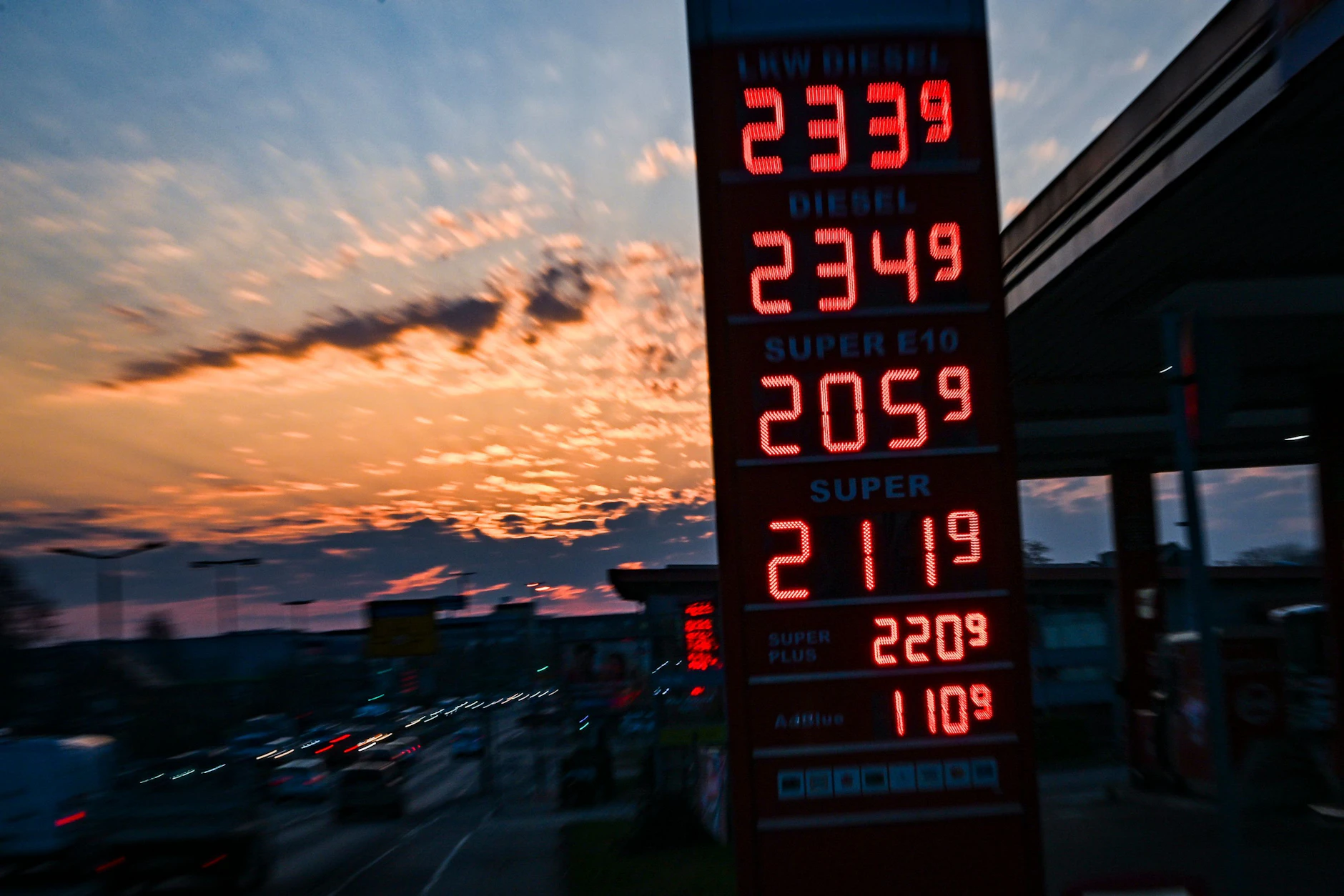 Auf einer Anzeigetafel einer Tankstelle stehen bei Sonnenaufgang die aktuellen Preise für Benzin und Diesel. Seit dem Krieg der USA und Israels gegen den Iran liegen die Benzin- und Dieselpreise über 2 Euro pro Liter.