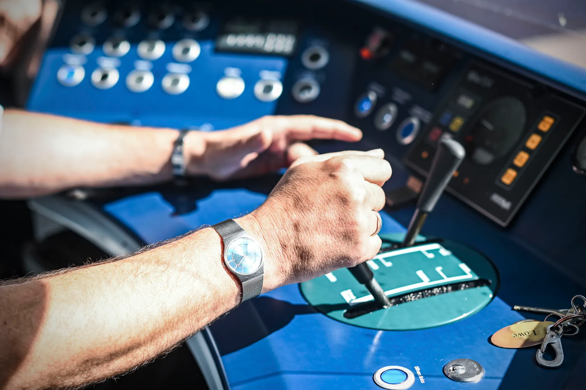 Die Arme und Hände eines Menschen, der legal im Führerstand sitzt: Ein Mitarbeiter der S-Bahn Berlin GmbH steuert einen Zug durch Berlin und das angrenzende Brandenburg.