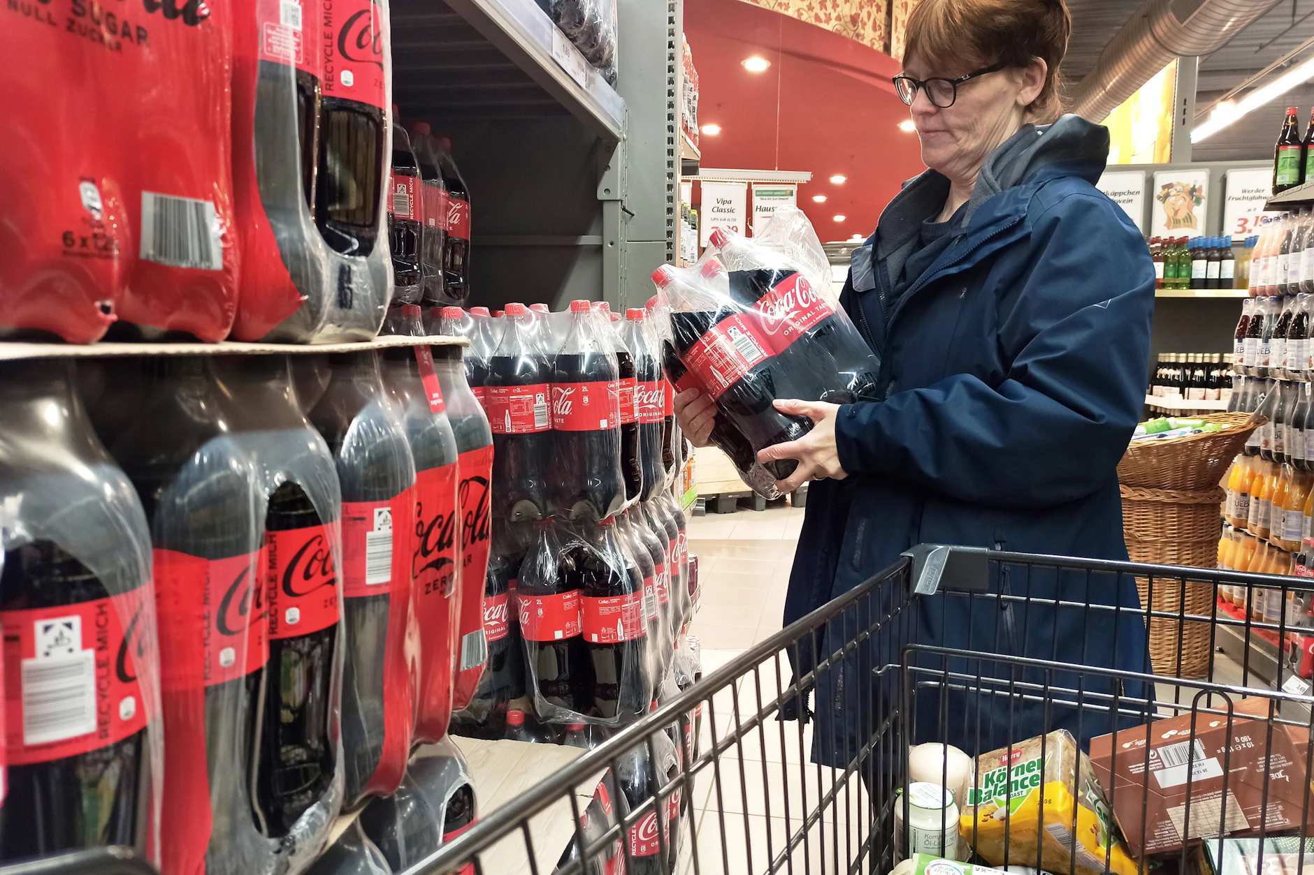 Eine Kundin greift im Supermarkt zu einem Multipack Cola. Sollte die geplante Zuckersteuer kommen, werden zuckergesüßte Erfrischungsgetränke künftig teurer.