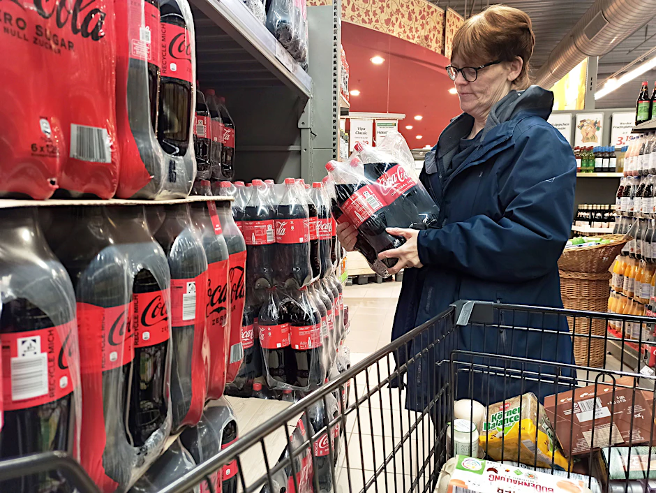 Eine Kundin greift im Supermarkt zu einem Multipack Cola. Sollte die geplante Zuckersteuer kommen, werden zuckergesüßte Erfrischungsgetränke künftig teurer.