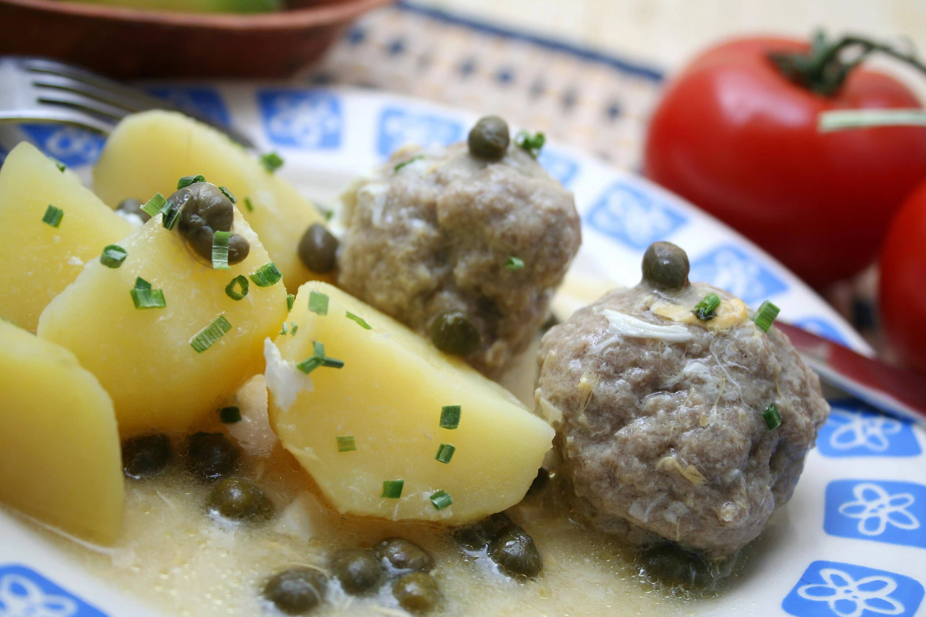 Königsberger Klopse kommen zusammen mit Salzkartoffeln auf den Tisch.