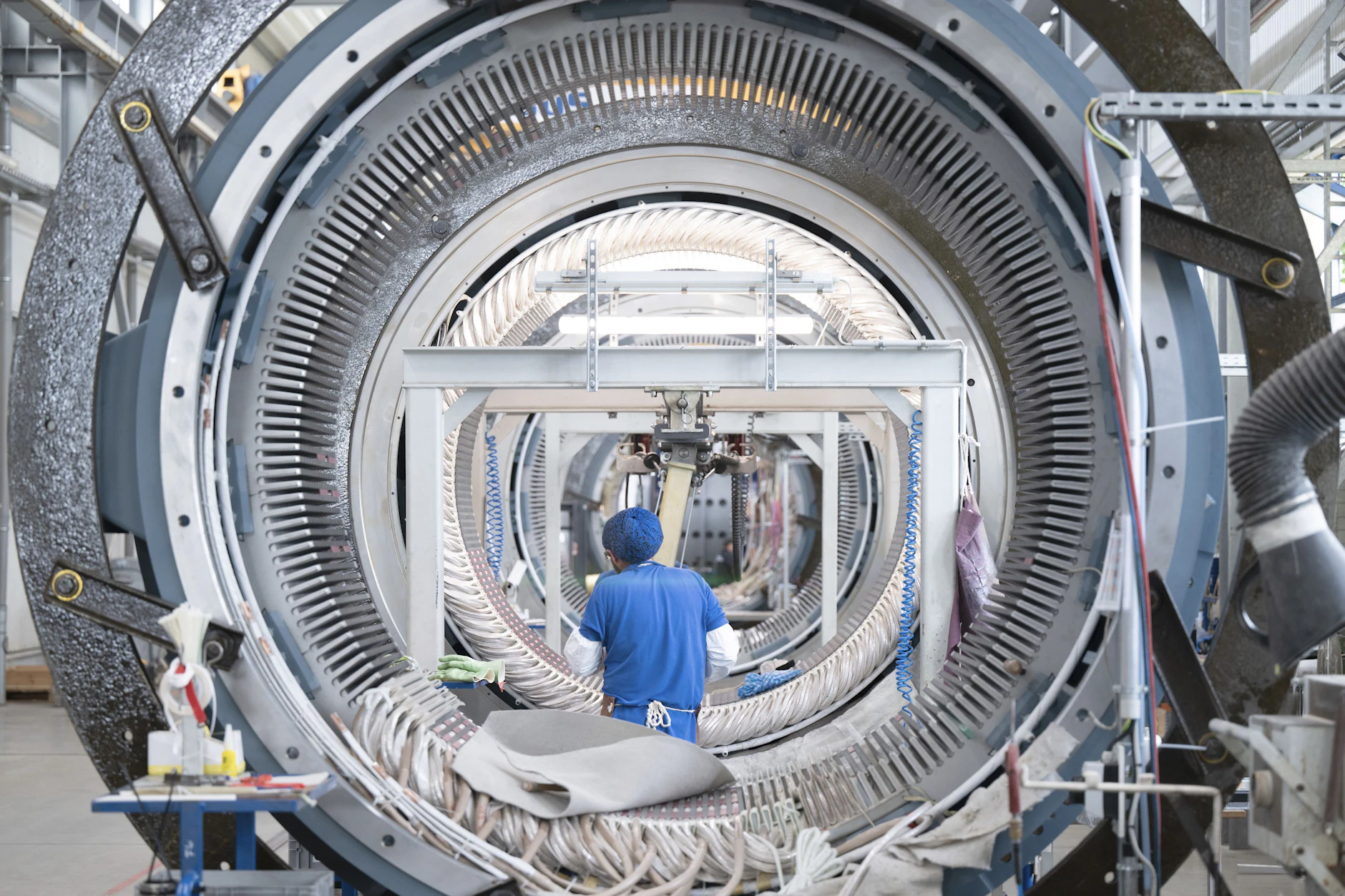 Ein Mitarbeiter der Partzsch Unternehmensgruppe arbeitet in einer Fertigungshalle an einem Windkraftstator für Windkraftanlagen. (Archiv)