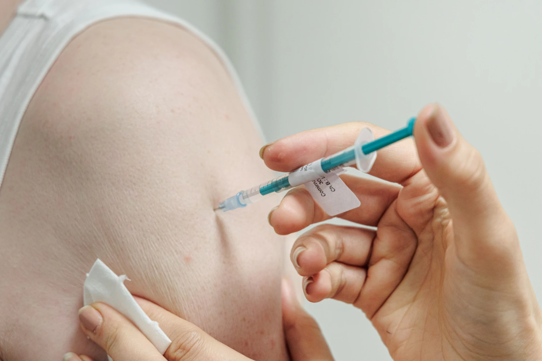 Eine Ärztin impft einen Mann gegen Covid-19.