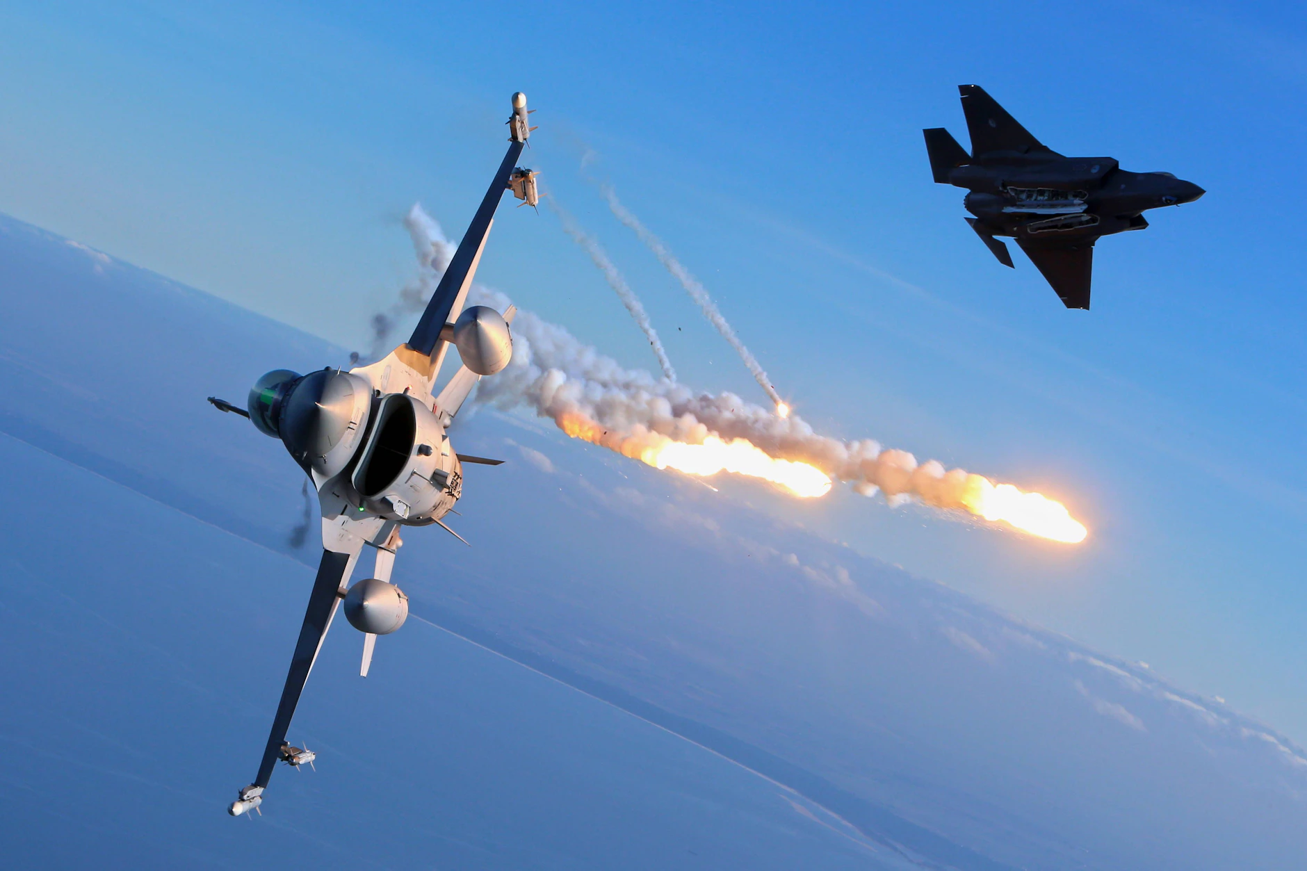 Kampfflugzeuge vom Typ Lockheed Martin F-35A Lighting II oben rechts und Lockheed Martin F-16 Fighting Falcon bei einer Übung