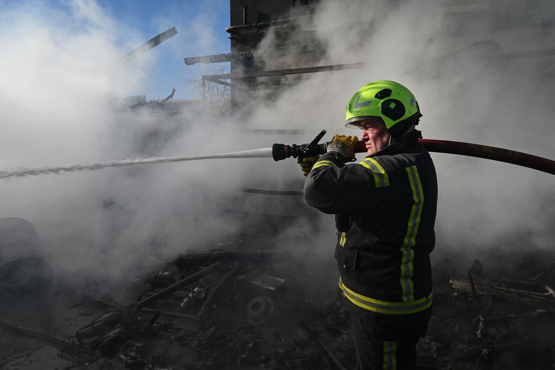 Ein Feuerwehrmann löscht ein Feuer an einem Ort eines Angriffs in der Stadt Browary nahe Kiew.