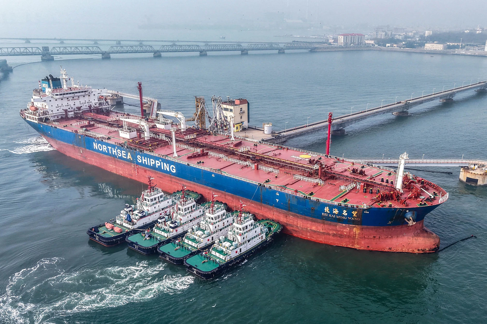 Schlepper ziehen einen Rohöltanker zu seinem Liegeplatz am Ölterminal im Hafen von Qingdao in der ostchinesischen Provinz Shandong am 23. März 2026.