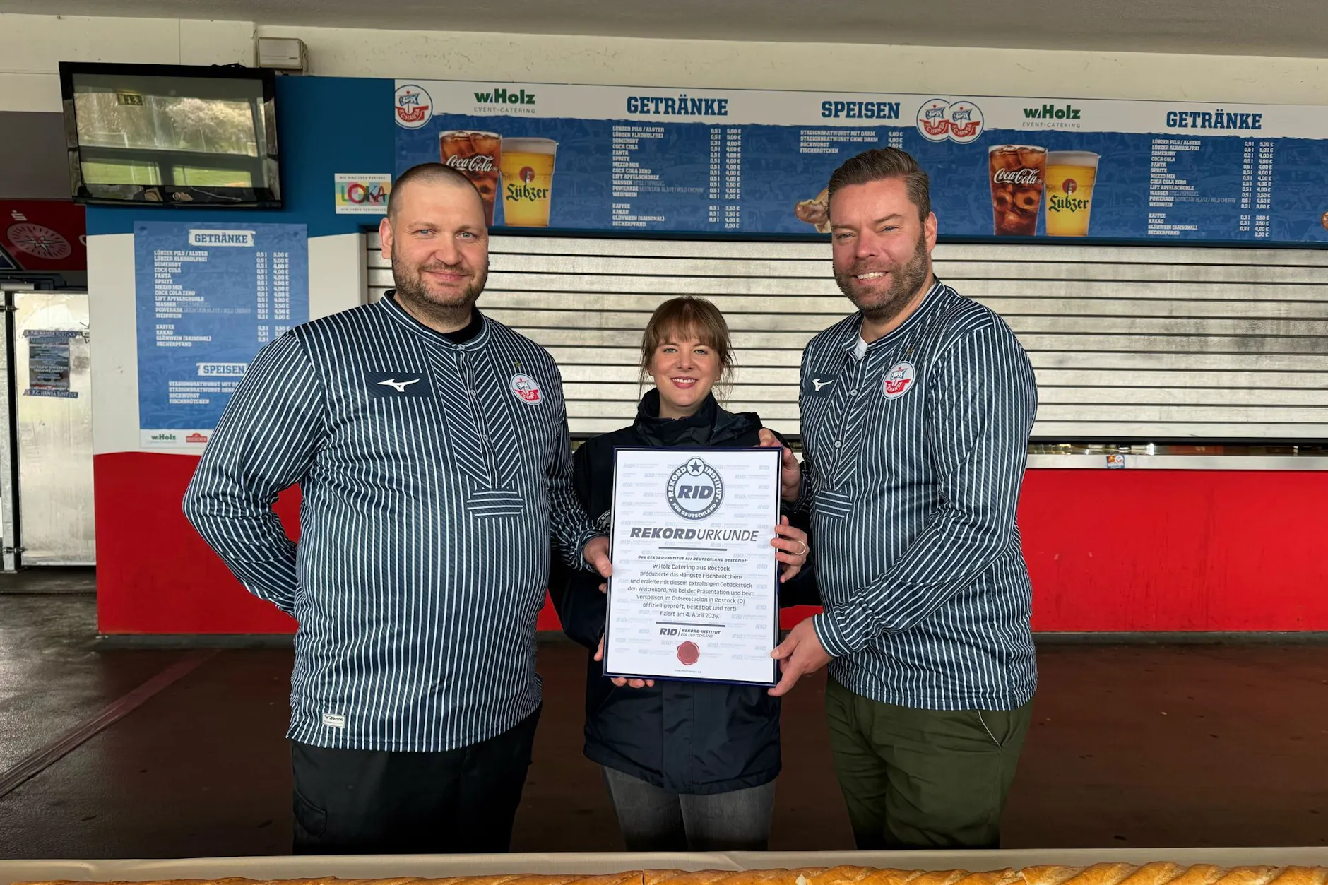 Rekord-Richterein Laura Koblischek (M) übergibt dem Geschäftsführer Christoph Wulff (r) und Küchenchef Jens Schaumburg (l) die Rekord-Urkunde.
