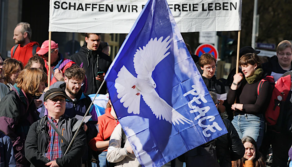 Eine Flagge mit der Friedenstaube ist auf einem Ostermarsch in Jena zu sehen.