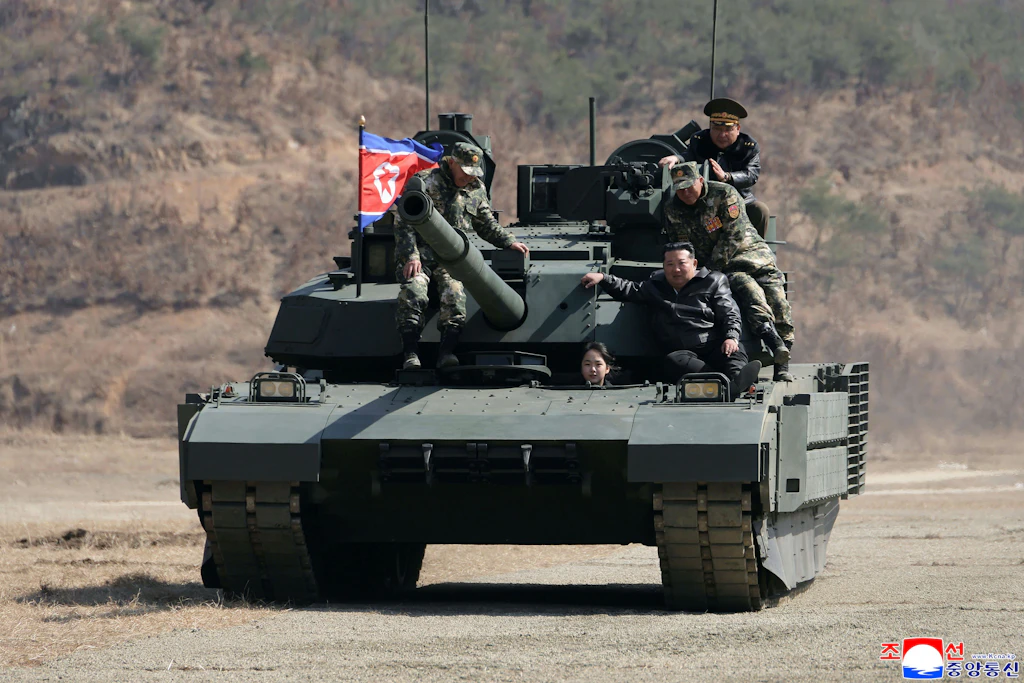 Kim Jong-un, der zusammen mit seiner Tochter Kim Ju-ae (vorne) mit einem Panzer auf einem militärischen Ausbildungsstützpunkt fährt.