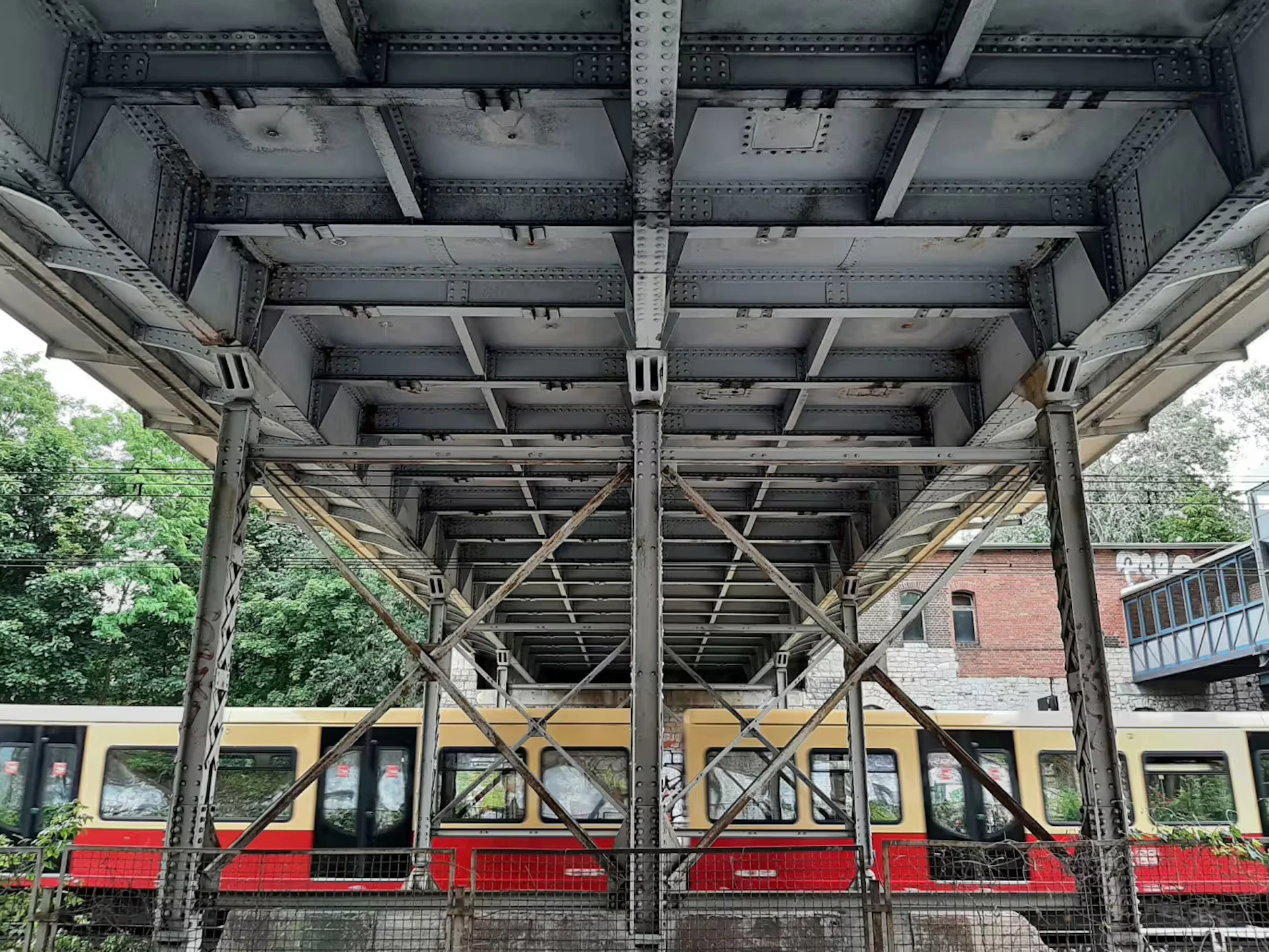 Unter den Brücke fährt die S-Bahnlinie S3 Richtung Erkner.