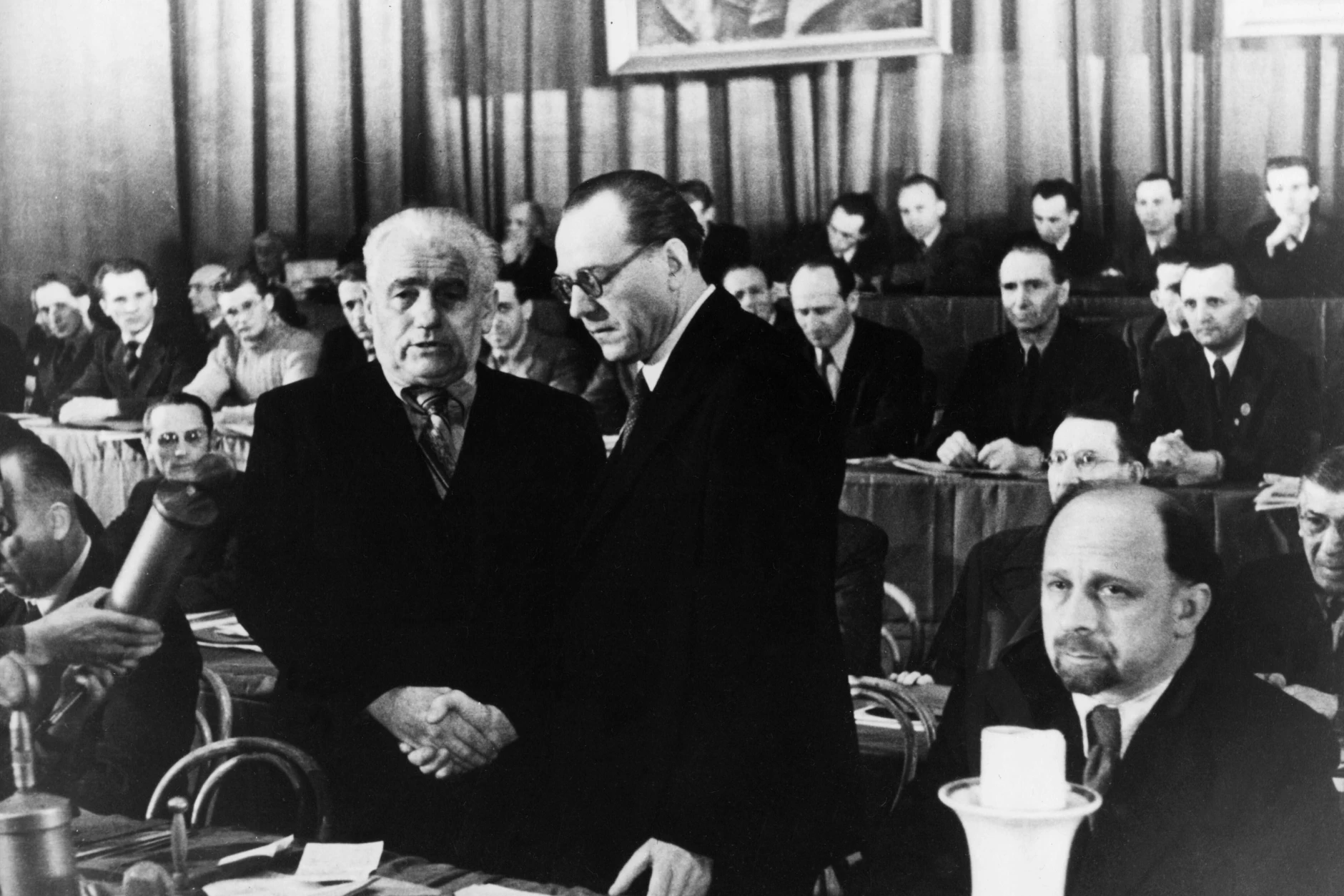Gründung der SED durch Vereinigung von SPD und KPD im April 1946 im Berliner Admiralspalast. Wilhelm Pieck (l.) und Otto Grotewohl, die beiden gewählten Vorsitzenden der SED, besiegeln die Vereinigung mit einem Händedruck, rechts: Walter Ulbricht.