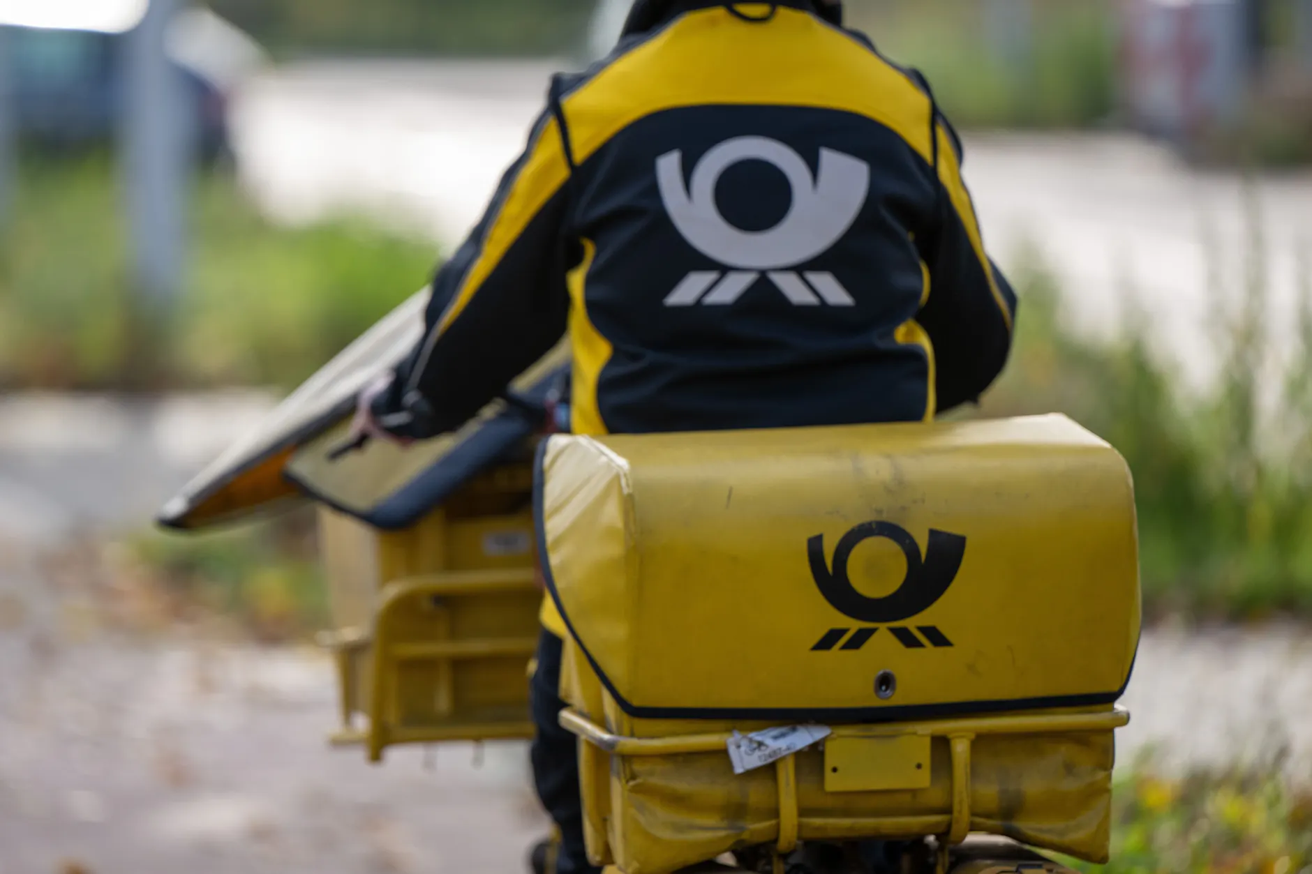 Eine Briefträgerin der Deutschen Post fährt auf ihrem Postfahrrad durch Berlin.