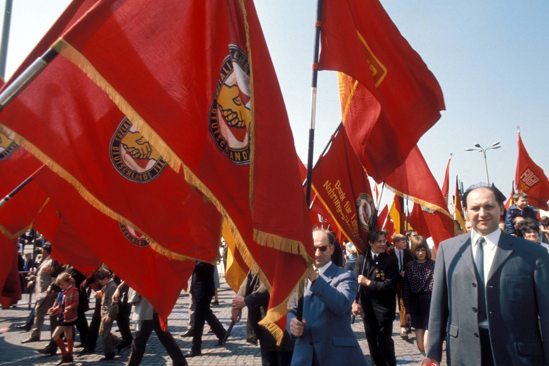 Teilnehmer einer Demonstration zum 1. Mai tragen in Ost-Berlin SED-Fahnen.
