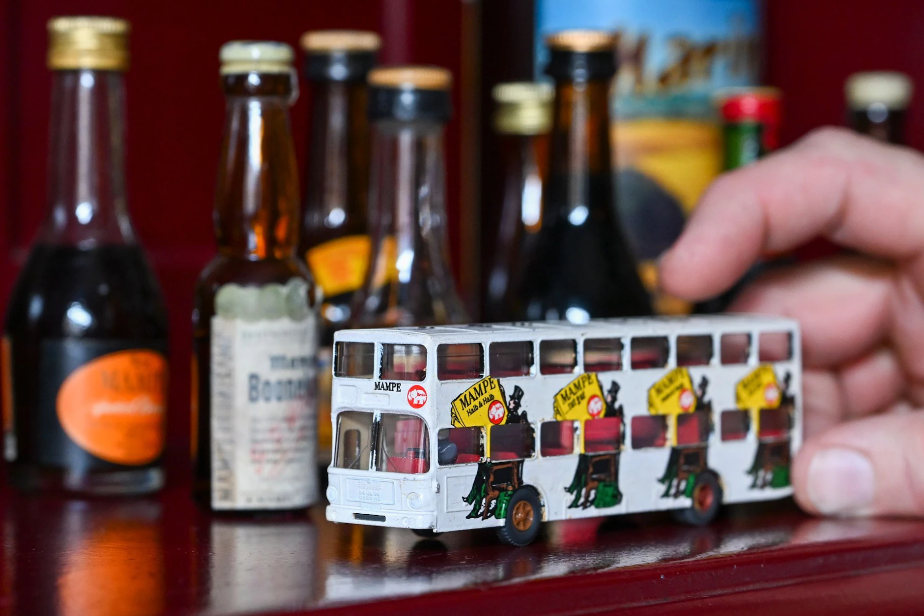 Ein Miniatur-Werbebus und alte Sorten von Spirituosen stehen in der Mampe Manufaktur Am Tempelhofer Berg.