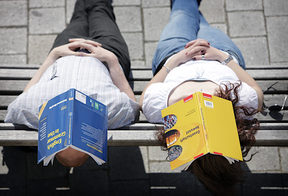 Lektüre zu anstrengend: Studenten nutzen Bücher als Sonnenschutz.