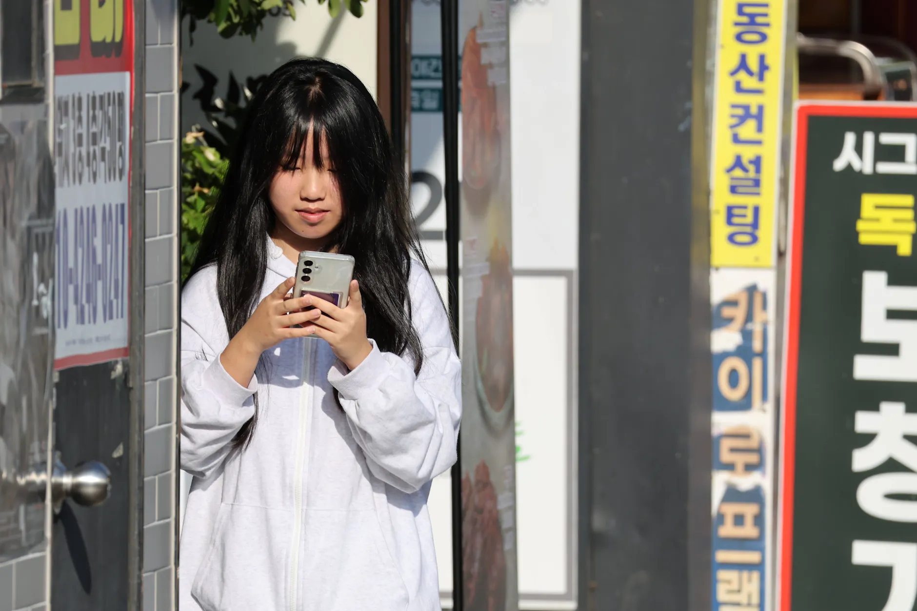 Eine Frau nutzt in Busan ihr Smartphone. In Südkorea bleibt Internetzugang auch nach dem Datenlimit.