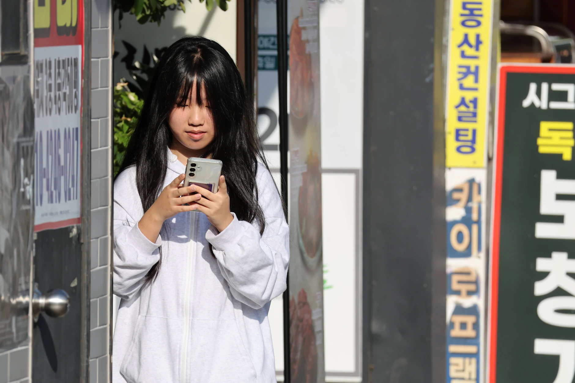 Eine Frau nutzt in Busan ihr Smartphone. In Südkorea bleibt Internetzugang auch nach dem Datenlimit.